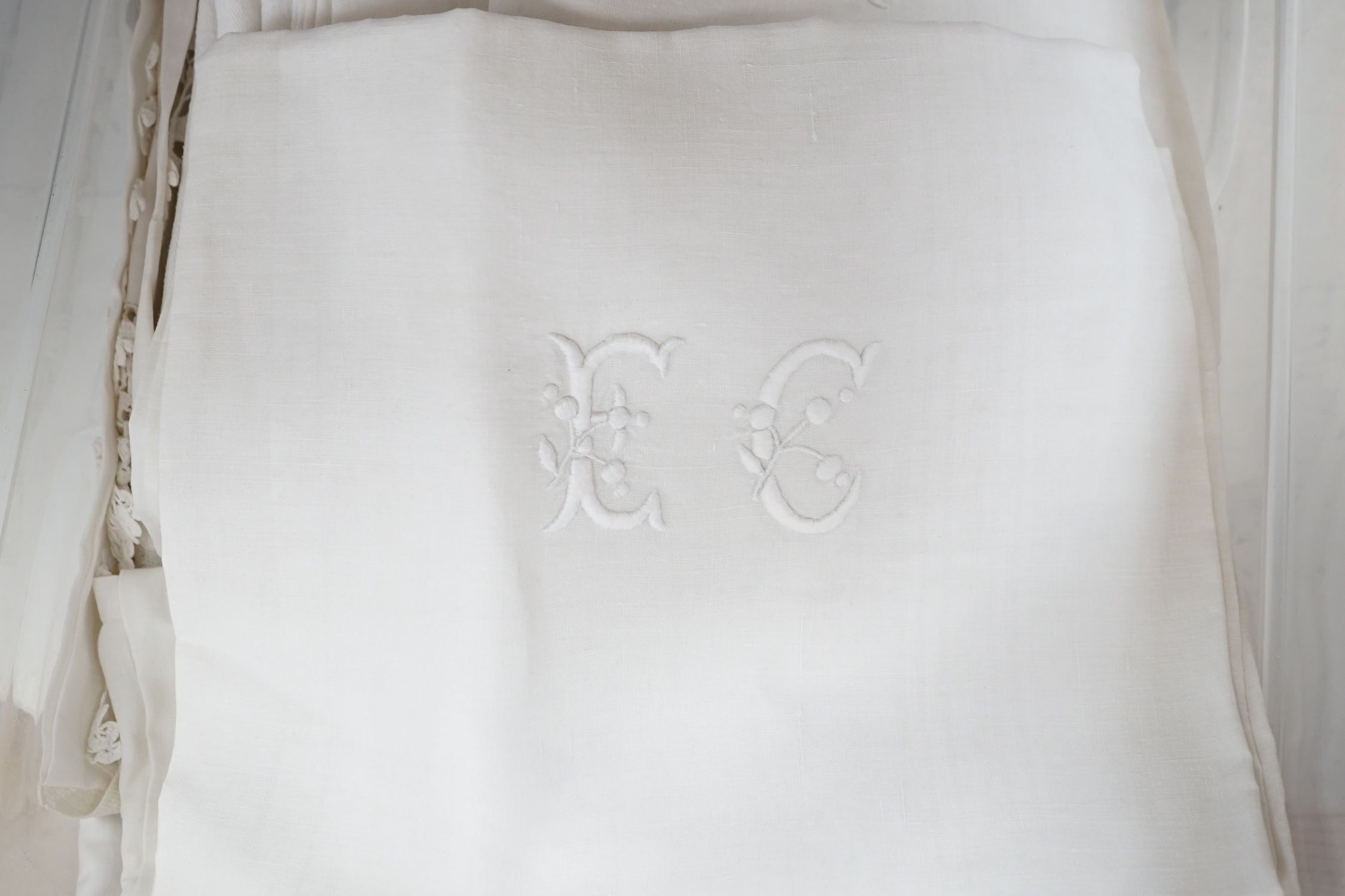 Two large linen white-worked table cloths, a collection of smaller crochet cloths and various sized monogrammed linen napkins, all linen laundered and starched. Condition - good